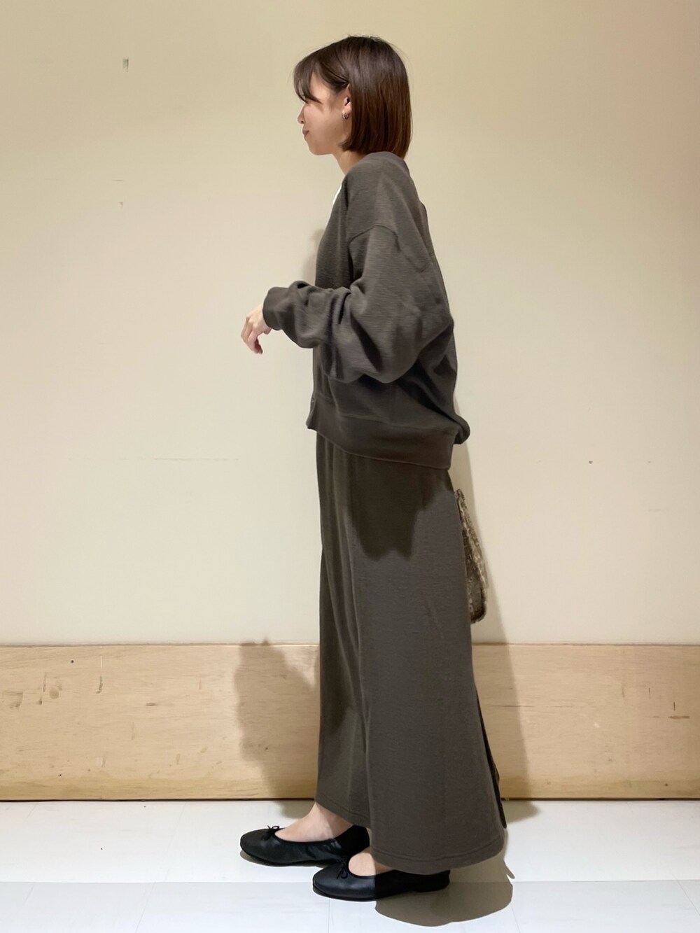 ベージュ系のトートバッグ、ホワイト系のタンクトップ、グレー系のカーディガン/ボレロを着用したレディースの秋コーディネートの4枚目の写真