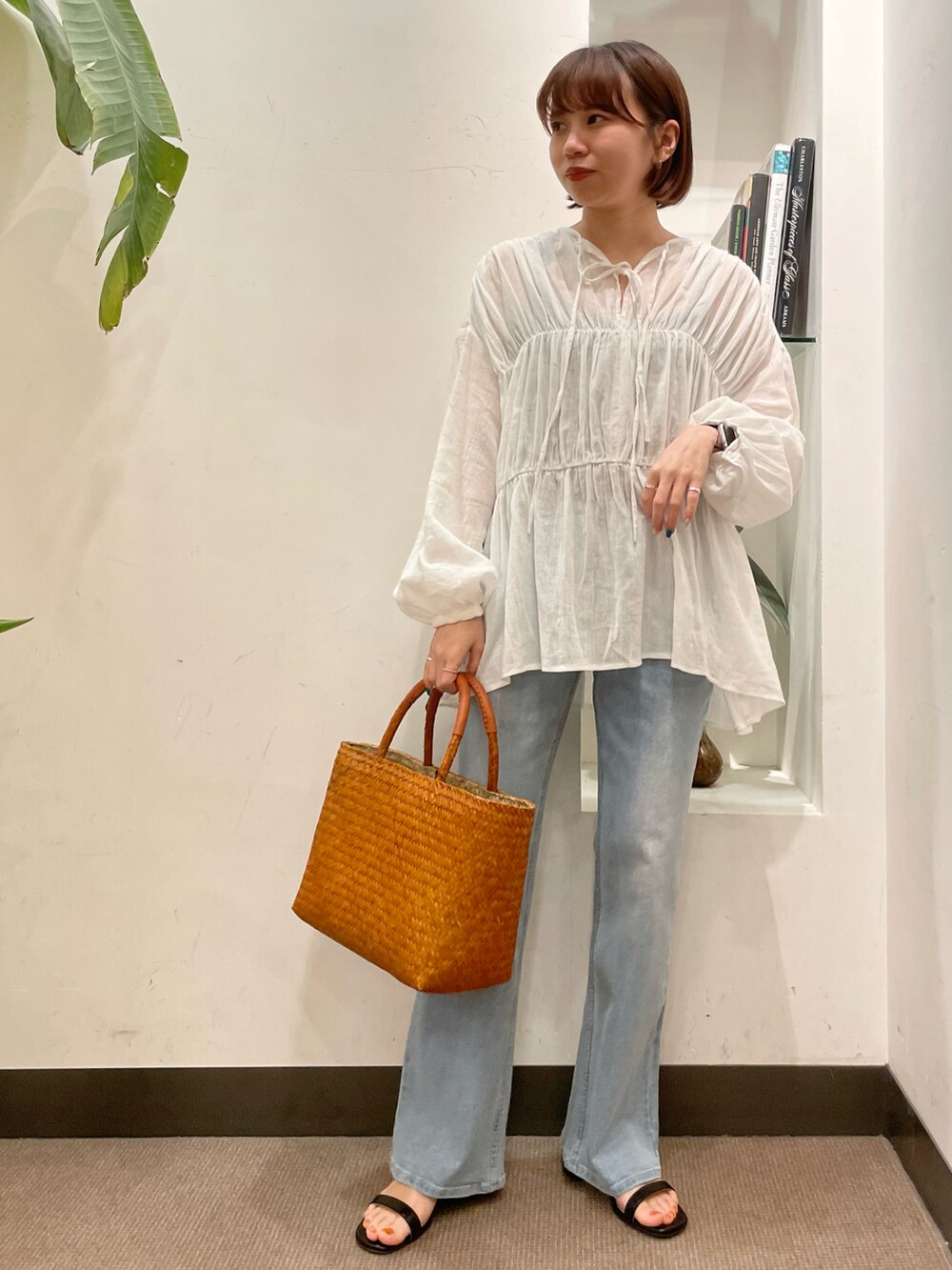 ブルー系のデニムパンツ、ブラック系のサンダル、ホワイト系のシャツ/ブラウスを着用したレディースの春コーディネートの3枚目の写真