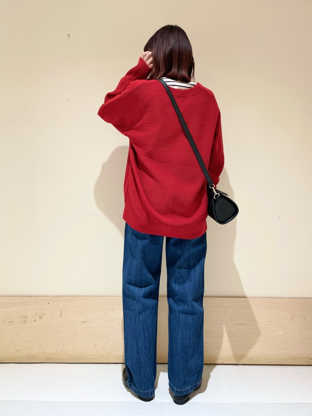 ブラック系のショルダーバッグ、レッド系のカーディガン/ボレロ、ホワイト系のTシャツ/カットソーを着用したレディースの冬コーディネートの7枚目の写真