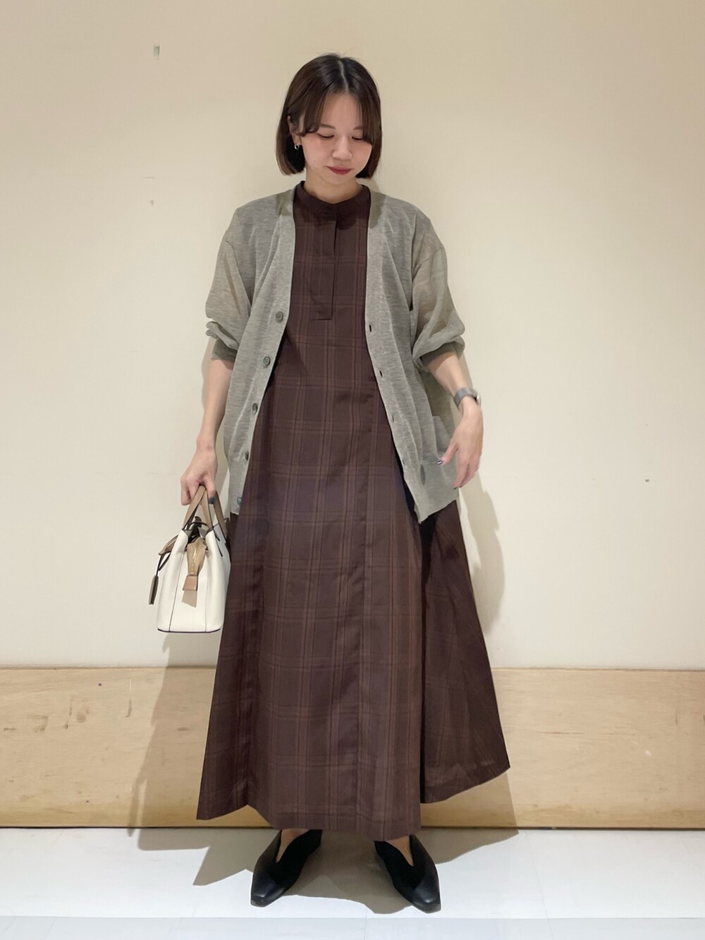 ブラウン系のワンピース、ベージュ系のカーディガン/ボレロ、ブラック系のパンプスを着用したレディースの夏コーディネートの2枚目の写真