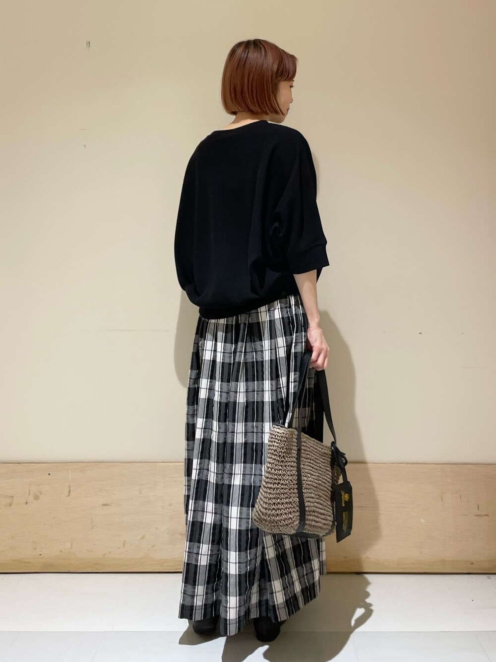 ブラック系のTシャツ/カットソー、ブラック系のスカート、グレー系のトートバッグを着用したレディースの春コーディネートの9枚目の写真