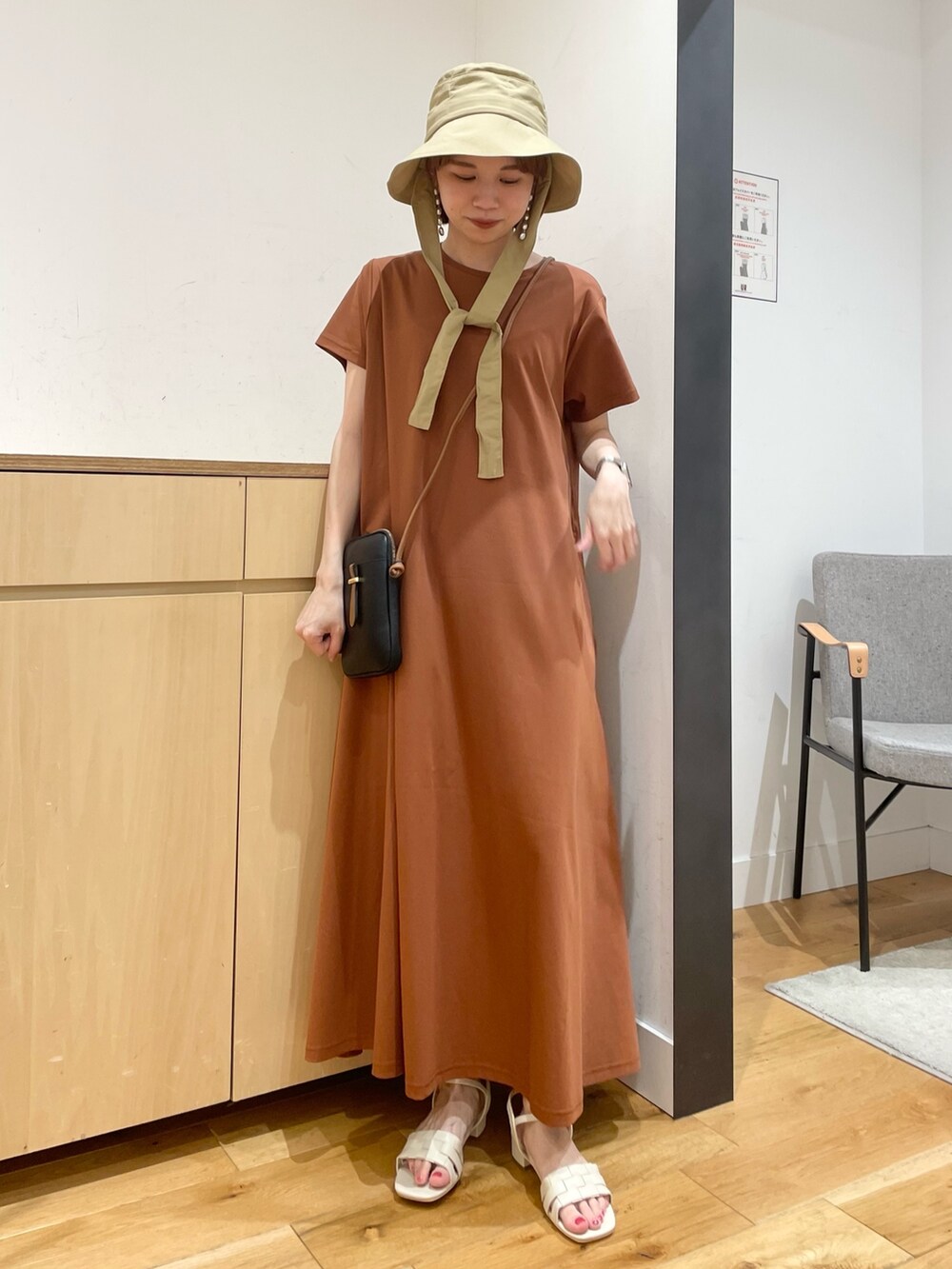 ホワイト系のサンダル、ブラウン系のワンピース、ブラック系のショルダーバッグを着用したレディースの夏コーディネートの2枚目の写真