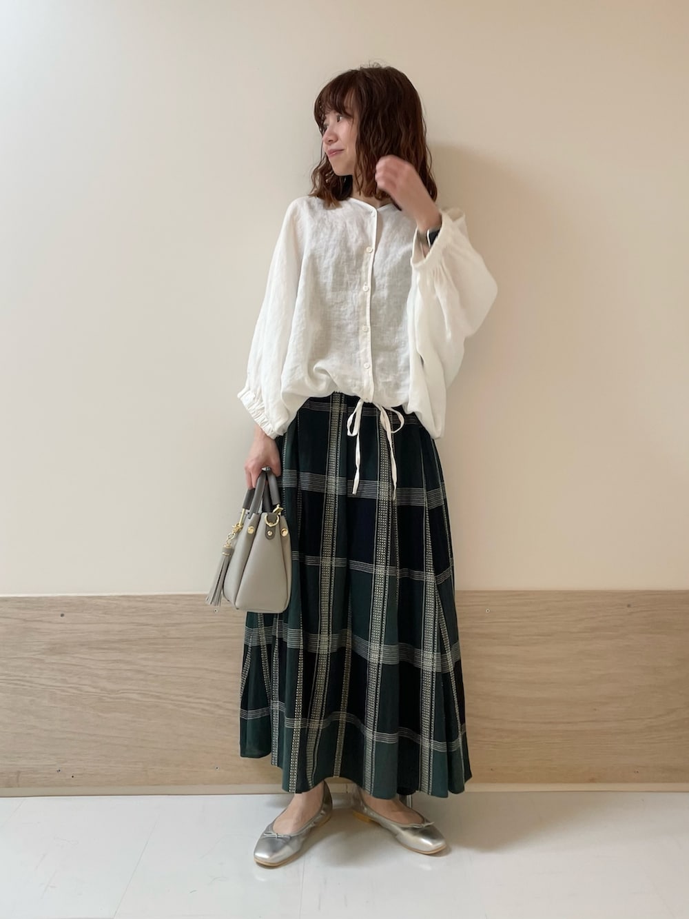 ホワイト系のシャツ/ブラウス、グリーン系のスカート、シルバー系のバレエシューズを着用したレディースの春コーディネートの2枚目の写真