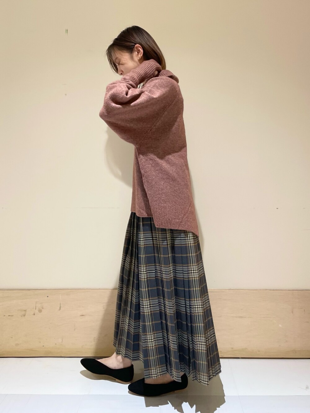 レッド系のニット/セーター、ブラック系のパンプス、グレー系のハンドバッグを着用したレディースの秋コーディネートの5枚目の写真