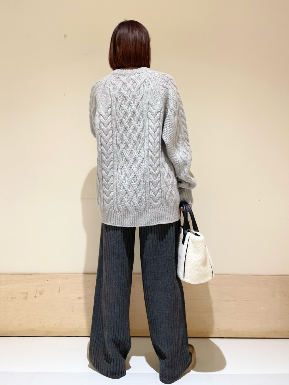 ホワイト系のショルダーバッグ、グレー系のニット/セーター、グレー系のその他パンツを着用したレディースの秋コーディネートの5枚目の写真