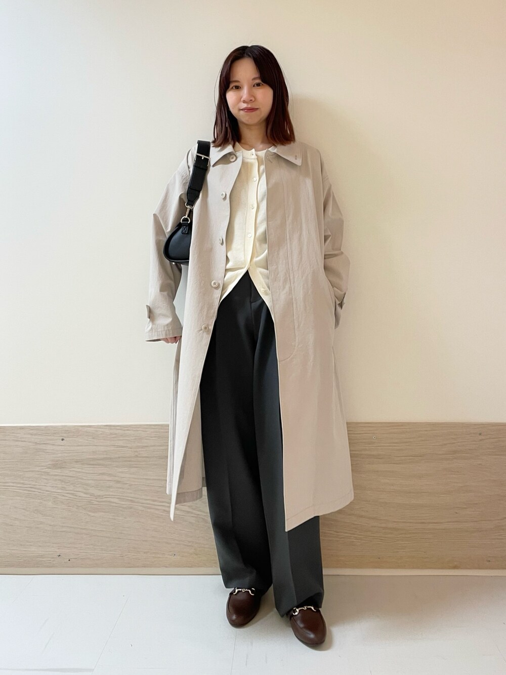 グレー系のその他パンツ、ブラック系のショルダーバッグ、グレー系のステンカラーコートを着用したレディースの春コーディネートの7枚目の写真