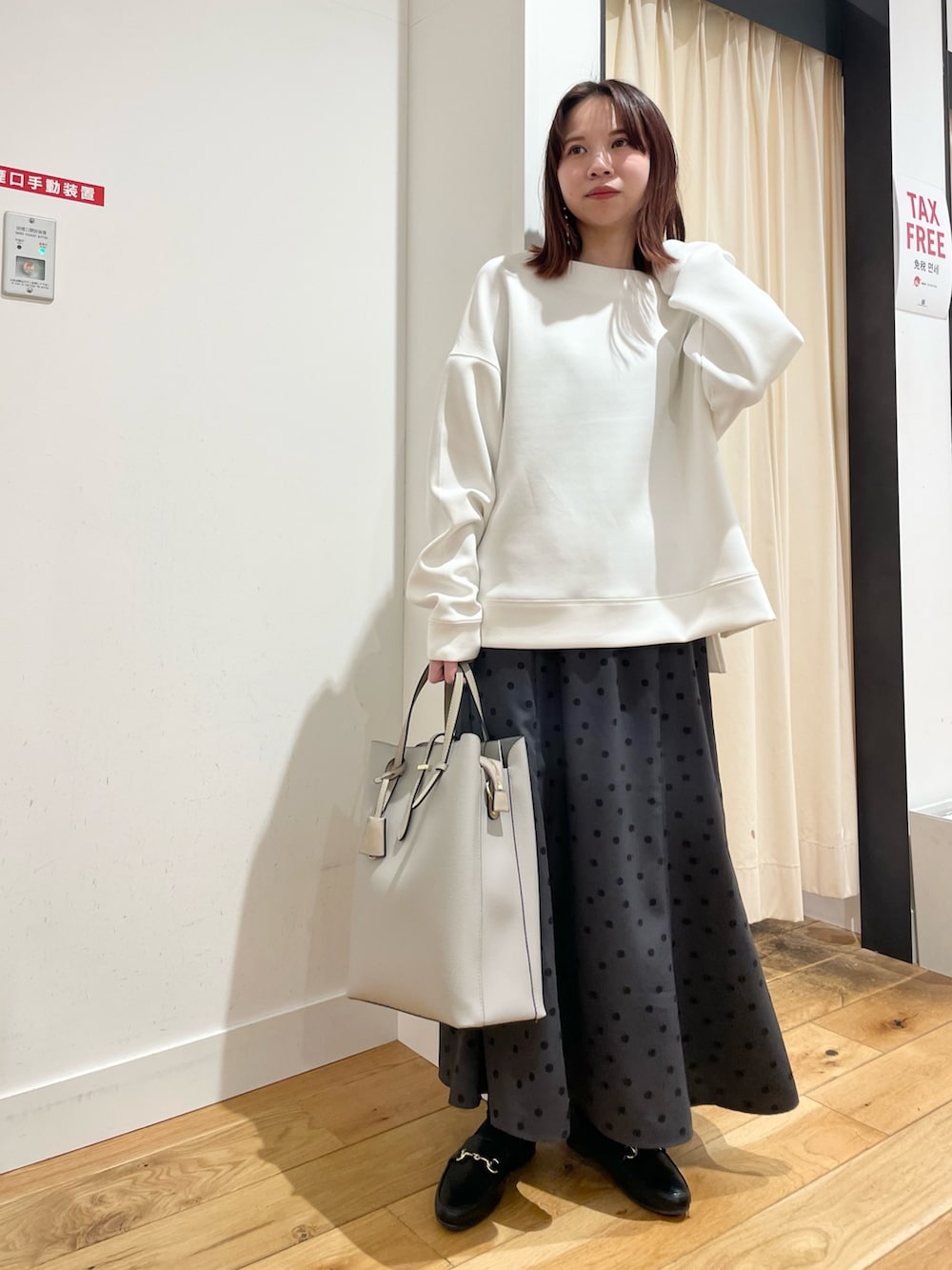 ホワイト系のTシャツ/カットソー、グレー系のスカートを着用したレディースの春コーディネートの2枚目の写真