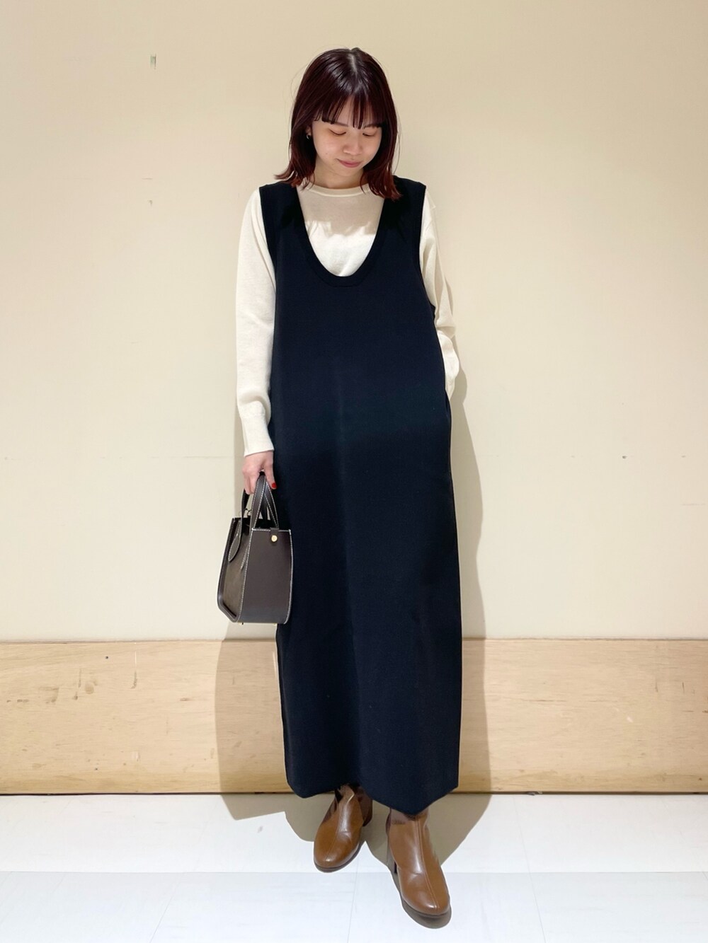 ブラック系のワンピース、ホワイト系のニット/セーターを着用したレディースの冬コーディネートの3枚目の写真