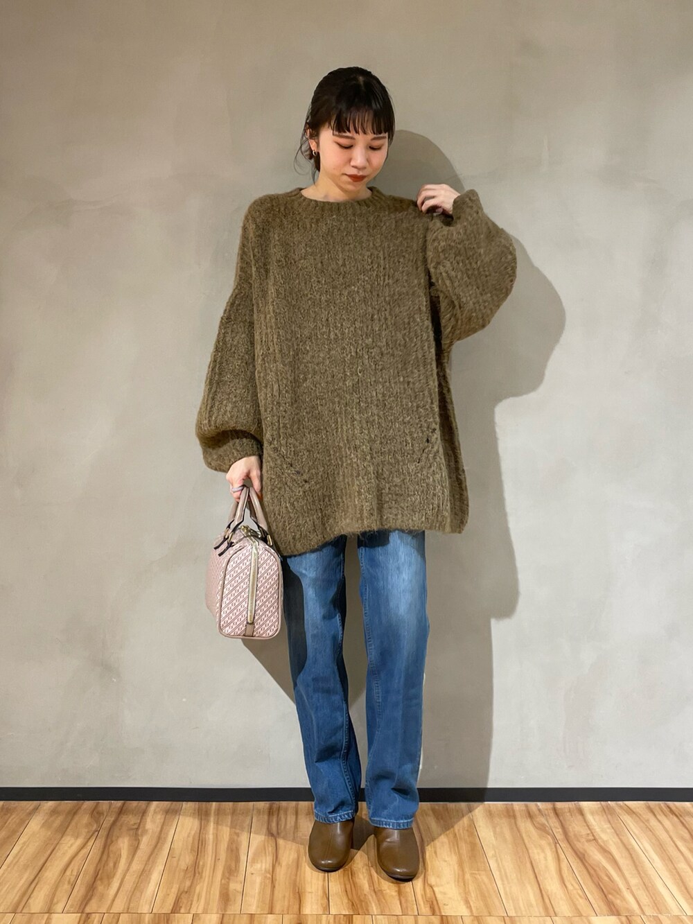 ブラウン系のニット/セーター、ブルー系のデニムパンツ、イエロー系のブーツを着用したレディースの秋コーディネートの2枚目の写真