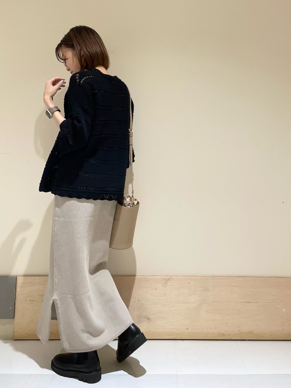 ベージュ系のショルダーバッグ、ブラック系のブーツ、ブラック系のニット/セーターを着用したレディースの秋コーディネートの6枚目の写真