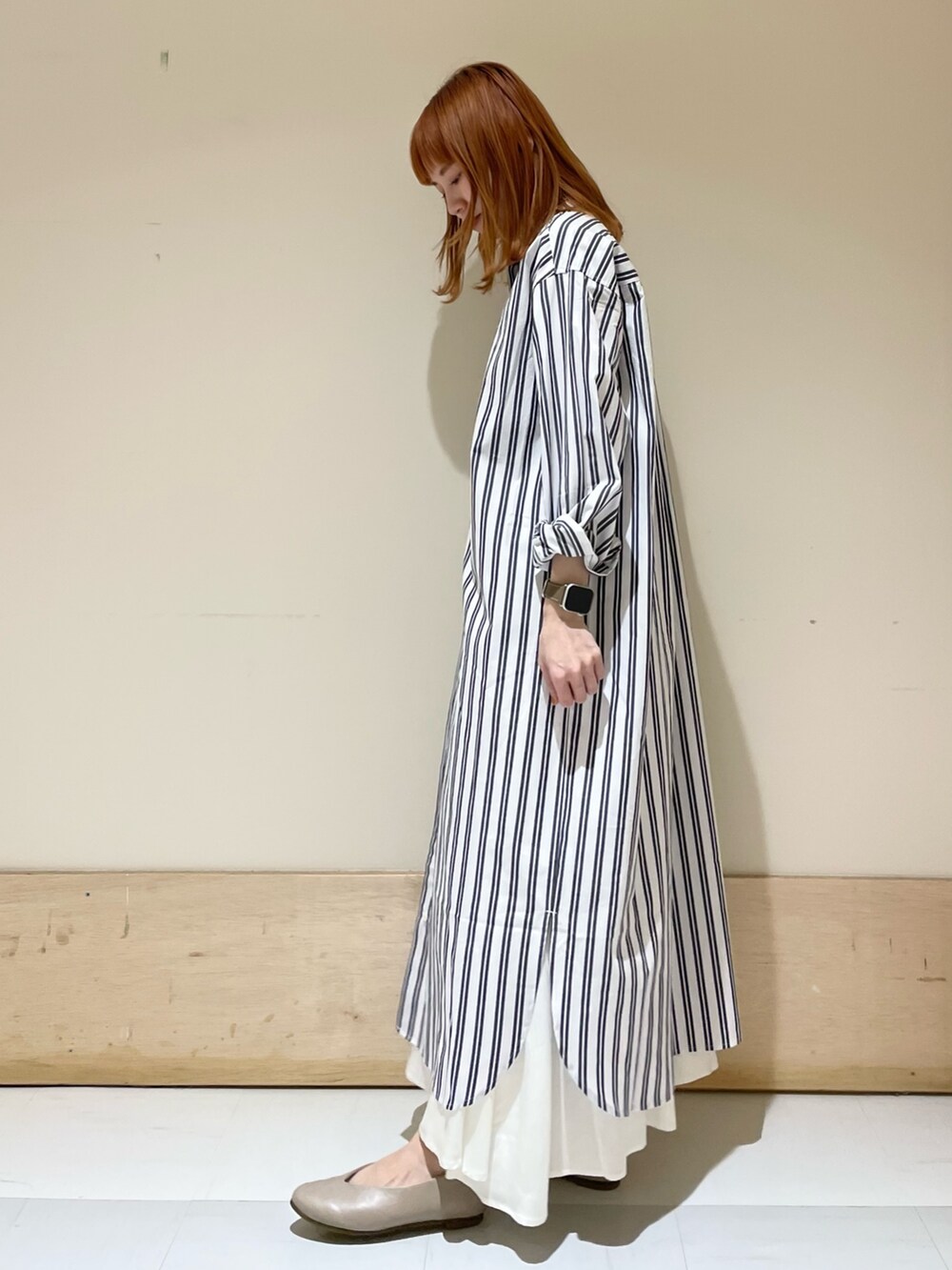 グリーン系のトートバッグ、ベージュ系のパンプス、ブルー系のワンピースを着用したレディースの春コーディネートの3枚目の写真