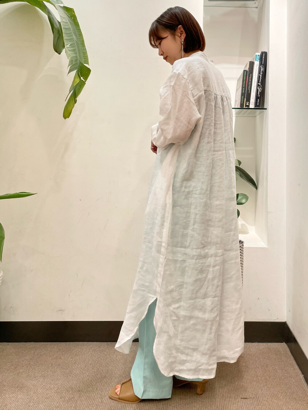 パープル系のトートバッグ、ホワイト系のワンピース、ベージュ系のサンダルを着用したレディースの夏コーディネートの3枚目の写真