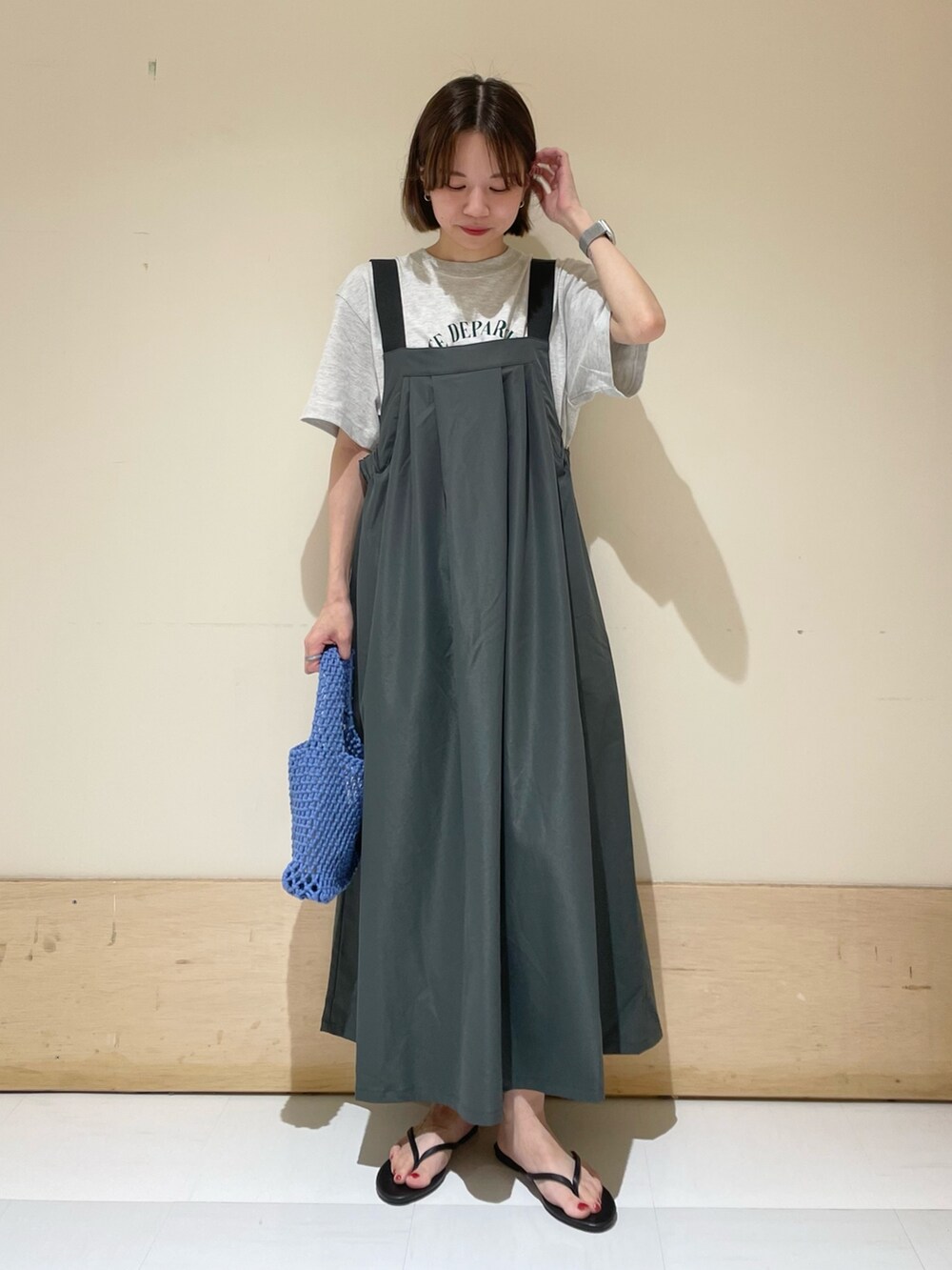 グレー系のワンピース、ブラック系のサンダル、ブルー系のハンドバッグを着用したレディースの夏コーディネートの3枚目の写真