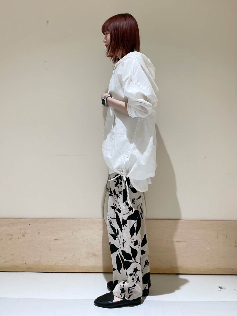 ホワイト系のパーカー、ホワイト系のタンクトップ、ベージュ系のハンドバッグを着用したレディースの春コーディネートの3枚目の写真