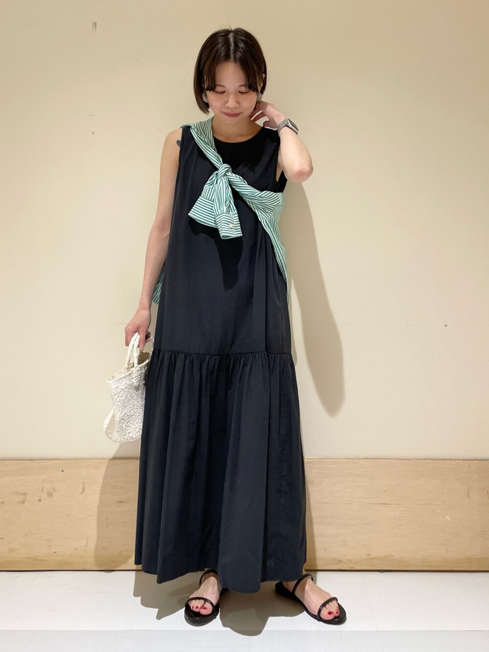 ブラック系のワンピース、グリーン系のシャツ/ブラウス、ホワイト系のハンドバッグを着用したレディースの夏コーディネートの3枚目の写真