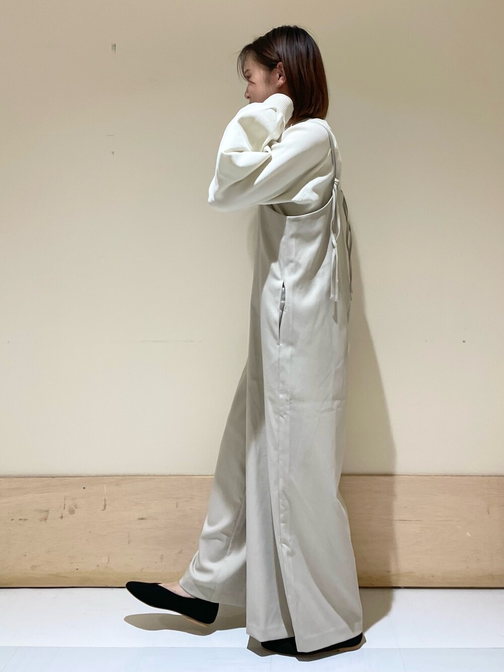 ホワイト系のニット/セーター、ベージュ系のサロペット/オーバーオール、イエロー系のトートバッグを着用したレディースの秋コーディネートの4枚目の写真