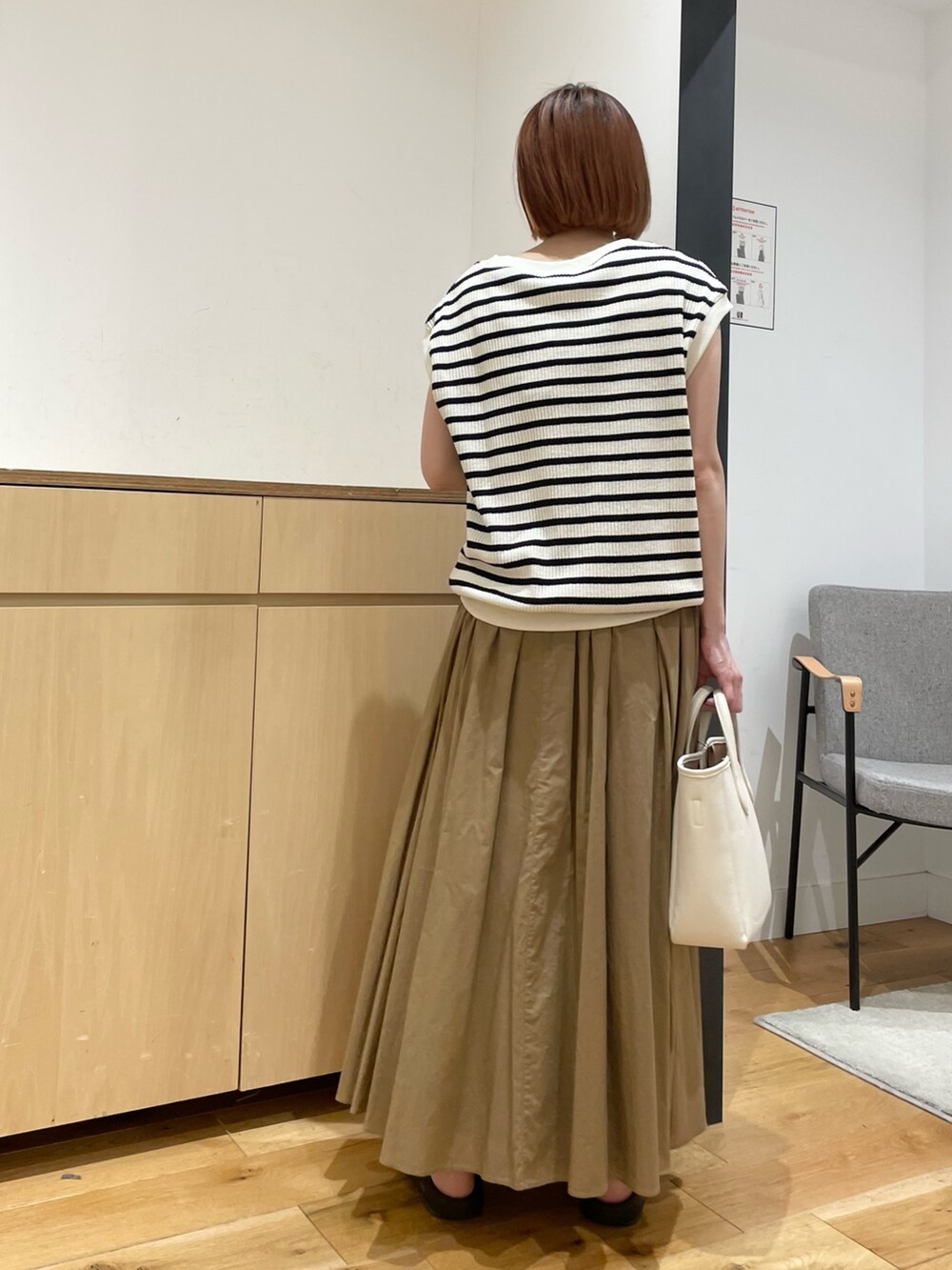 ホワイト系のTシャツ/カットソー、ベージュ系のスカート、ホワイト系のトートバッグを着用したレディースの春コーディネートの6枚目の写真