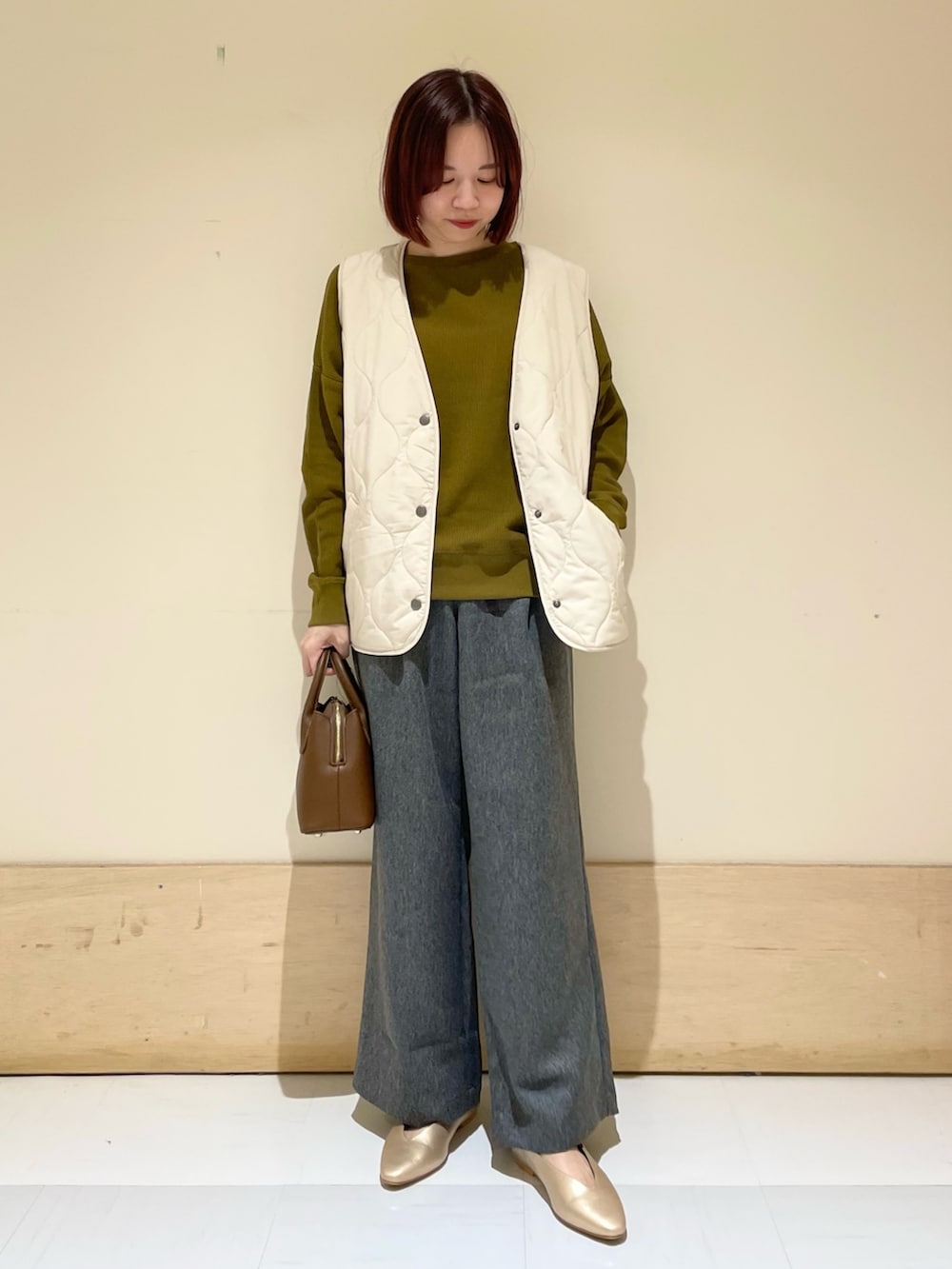 ゴールド系のパンプス、ブラウン系のショルダーバッグ、イエロー系のTシャツ/カットソーを着用したレディースの秋コーディネートの2枚目の写真