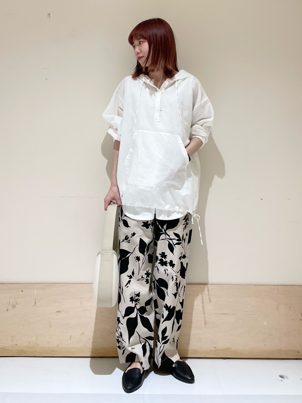 ホワイト系のパーカー、ホワイト系のタンクトップ、ベージュ系のハンドバッグを着用したレディースの春コーディネートの2枚目の写真