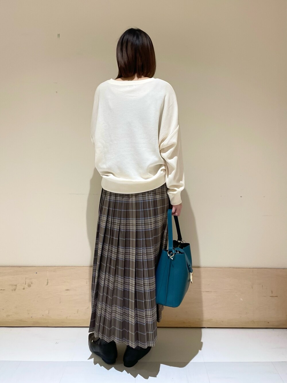 ブルー系のハンドバッグ、ブラック系のローファー、ベージュ系のTシャツ/カットソーを着用したレディースの秋コーディネートの7枚目の写真