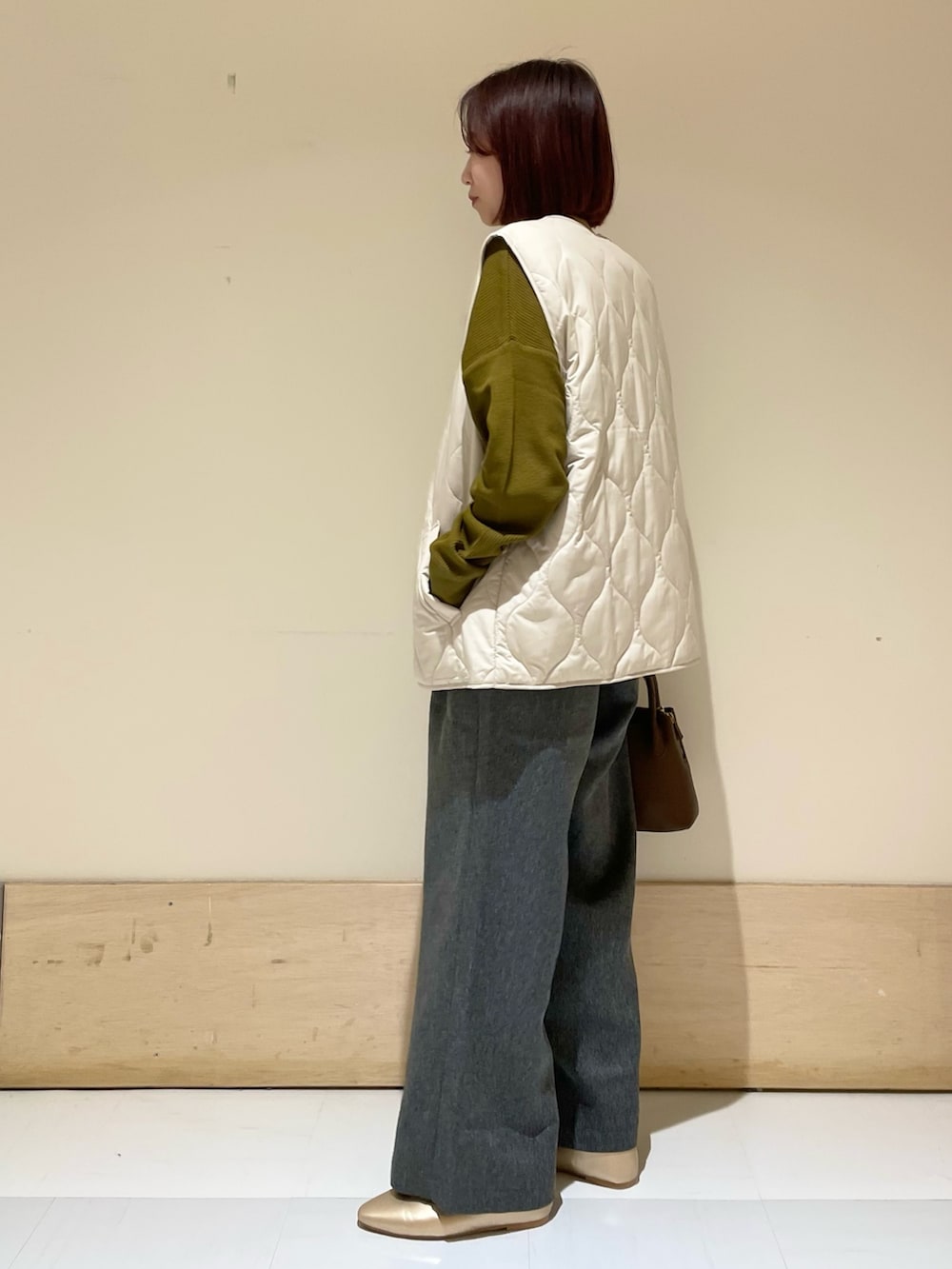 ゴールド系のパンプス、ブラウン系のショルダーバッグ、イエロー系のTシャツ/カットソーを着用したレディースの秋コーディネートの4枚目の写真