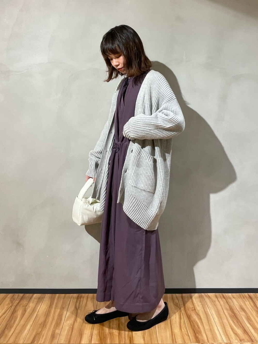 ブラック系のバレエシューズ、パープル系のワンピース、ホワイト系のカーディガン/ボレロを着用したレディースの秋コーディネートの2枚目の写真