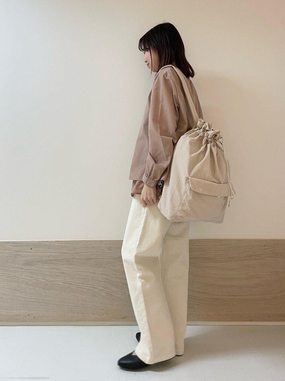 ベージュ系のデニムパンツ、ブラック系のパンプス、ピンク系のバックパック/リュックを着用したレディースの春コーディネートの3枚目の写真