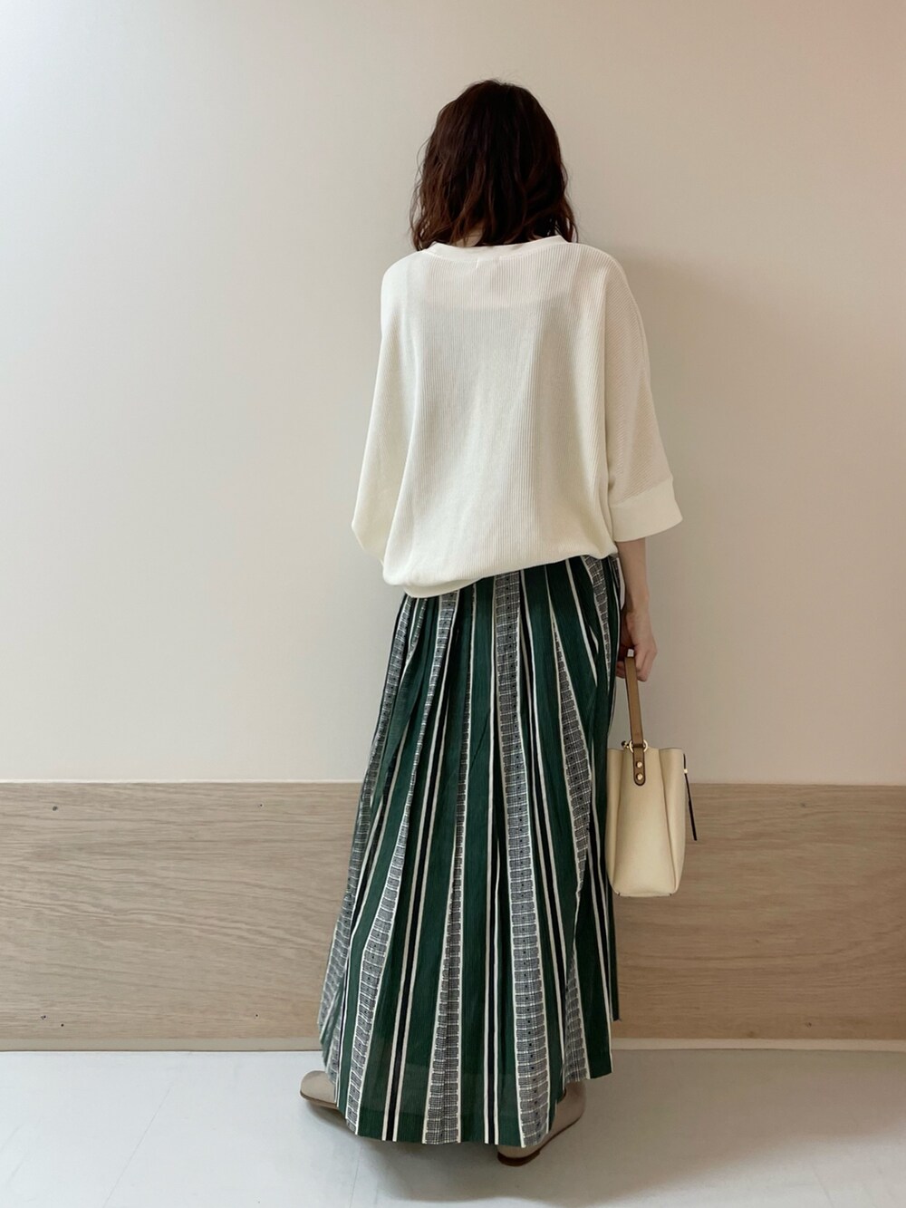ホワイト系のTシャツ/カットソー、グリーン系のスカート、ベージュ系のパンプスを着用したレディースの春コーディネートの6枚目の写真