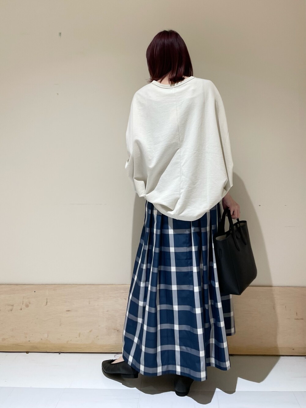 ベージュ系のTシャツ/カットソー、ブルー系のスカート、ブラック系のトートバッグを着用したレディースの春コーディネートの5枚目の写真