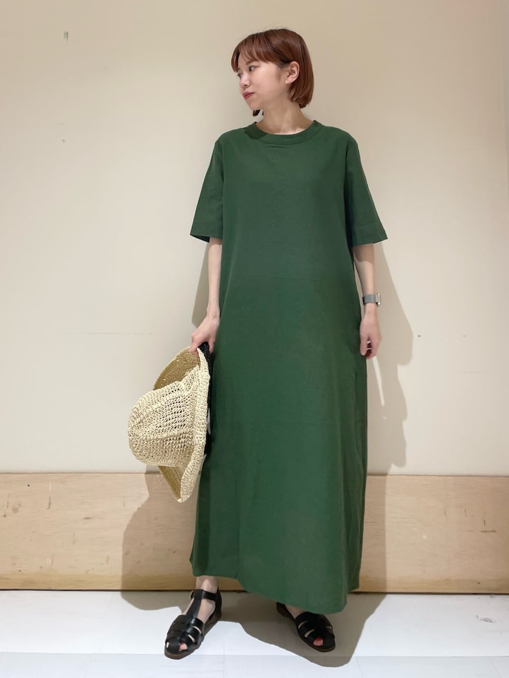 グリーン系のワンピース、ブラック系のサンダル、ブラック系のハンドバッグを着用したレディースの春コーディネートの4枚目の写真