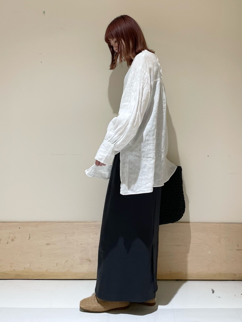 ホワイト系のシャツ/ブラウス、グレー系のスカート、ブラック系のかごバッグを着用したレディースの春コーディネートの4枚目の写真