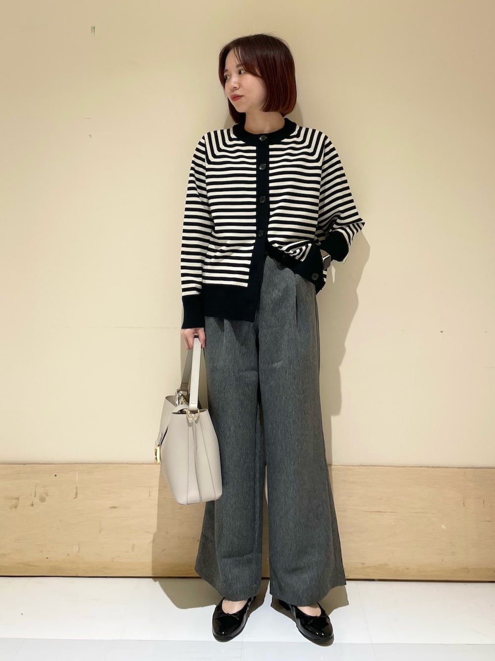 グレー系のその他パンツ、グレー系のハンドバッグ、ブラック系のパンプスを着用したレディースの秋コーディネートの2枚目の写真