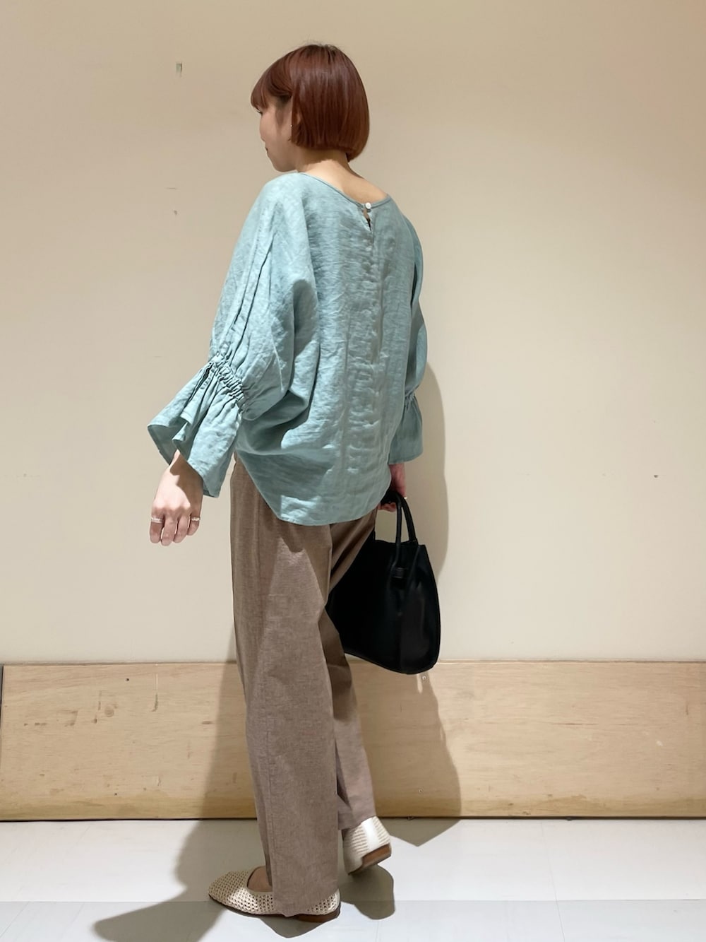 グリーン系のシャツ/ブラウス、ブラック系のトートバッグ、ホワイト系のバレエシューズを着用したレディースの春コーディネートの6枚目の写真