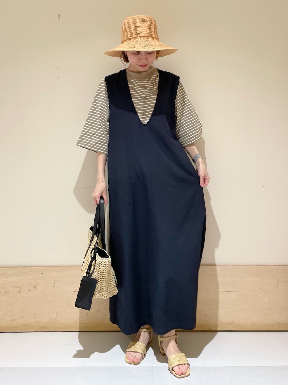 ベージュ系のサンダル、ブルー系のワンピース、ベージュ系のTシャツ/カットソーを着用したレディースの春コーディネートの2枚目の写真