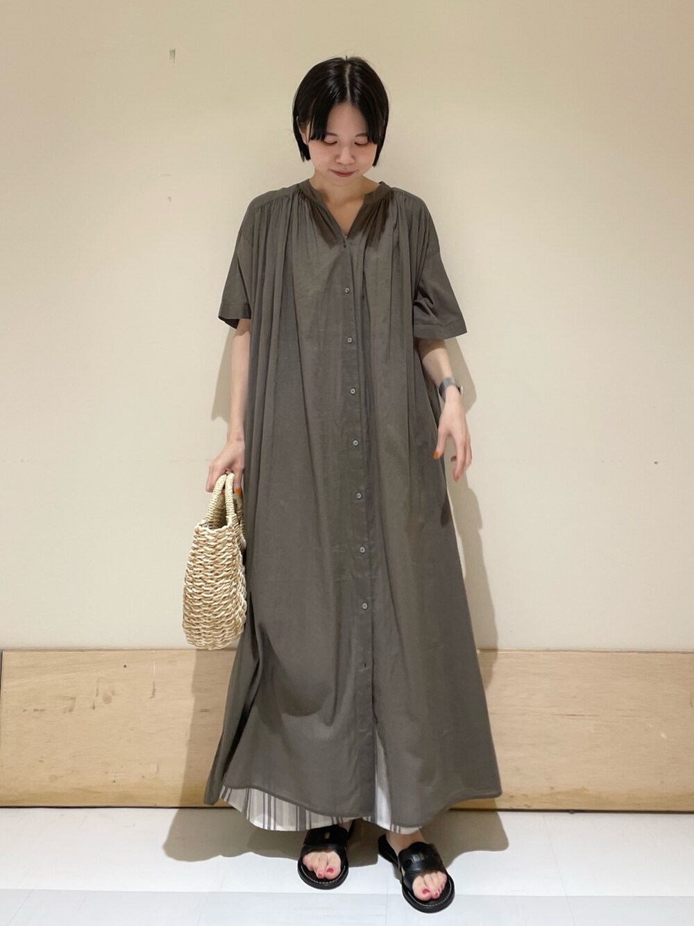 グリーン系のワンピース、ホワイト系のその他パンツ、ブラック系のサンダルを着用したレディースの夏コーディネートの2枚目の写真