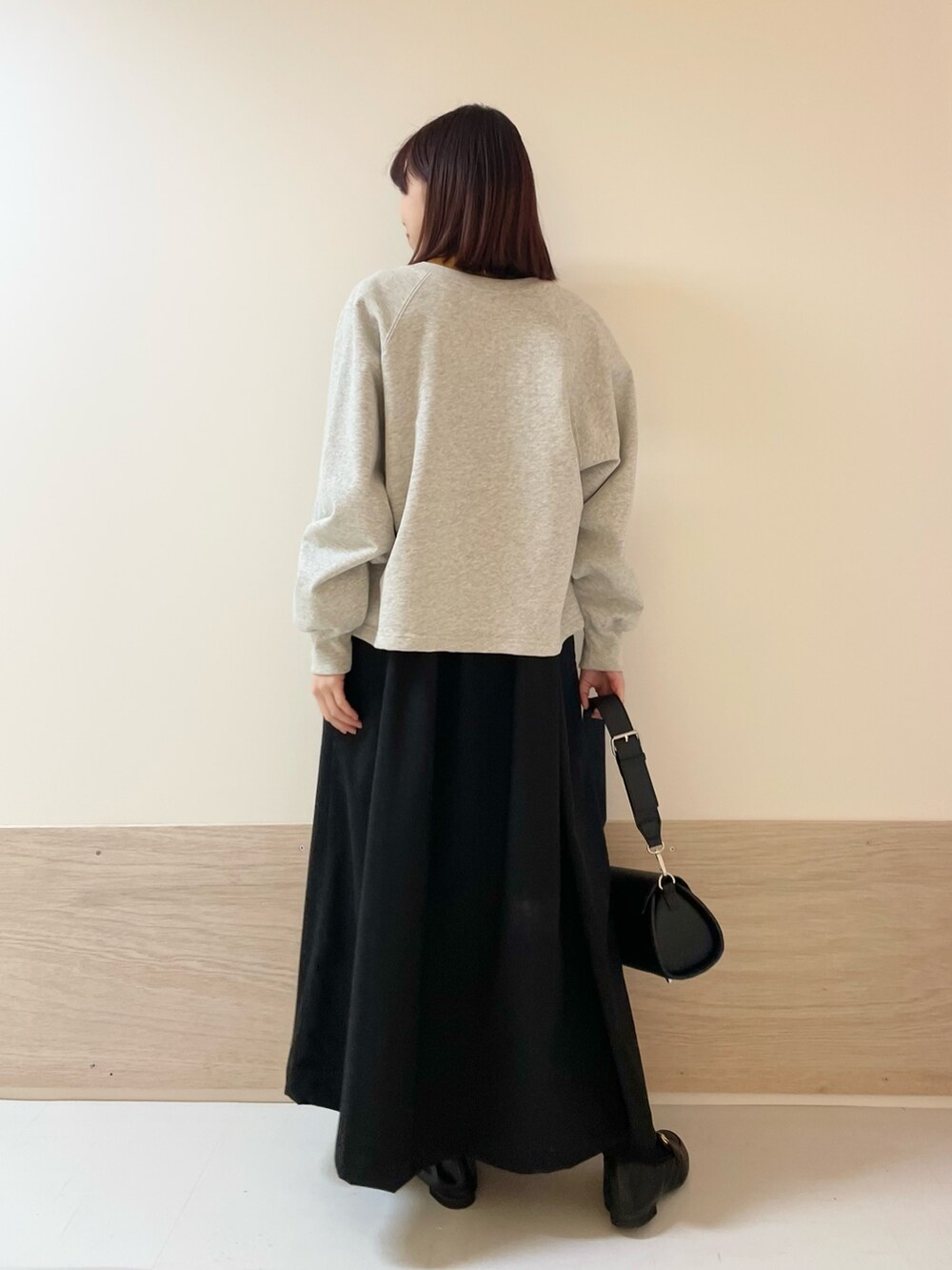 グレー系のカーディガン/ボレロ、イエロー系のニット/セーター、ブラック系のワンピースを着用したレディースの春コーディネートの6枚目の写真
