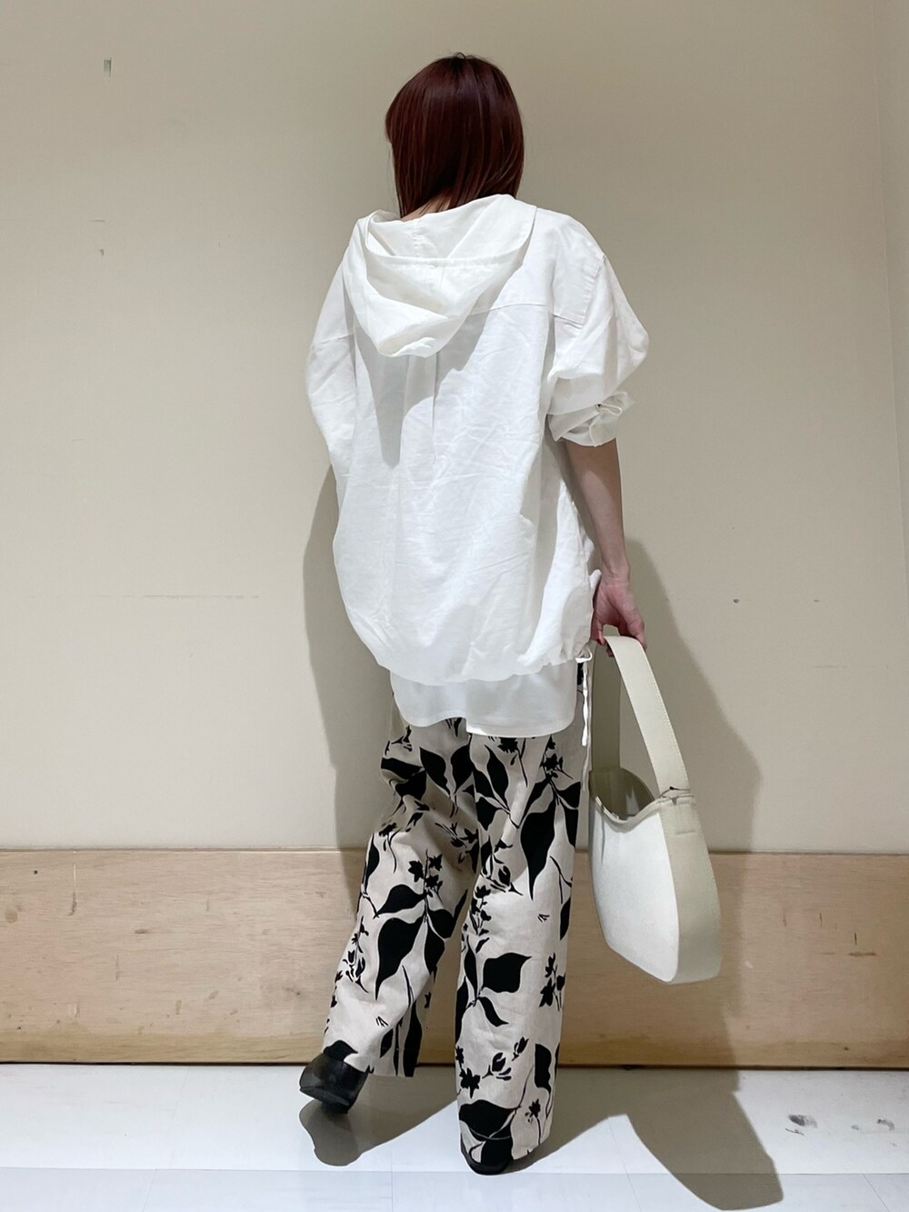 ホワイト系のパーカー、ホワイト系のタンクトップ、ベージュ系のハンドバッグを着用したレディースの春コーディネートの6枚目の写真