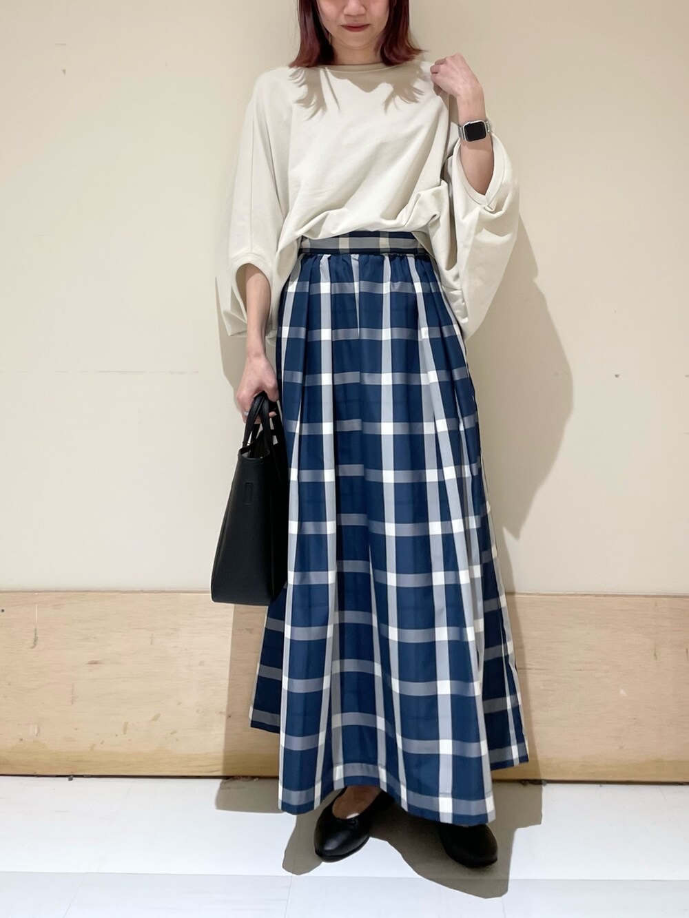 ベージュ系のTシャツ/カットソー、ブルー系のスカート、ブラック系のトートバッグを着用したレディースの春コーディネートの3枚目の写真