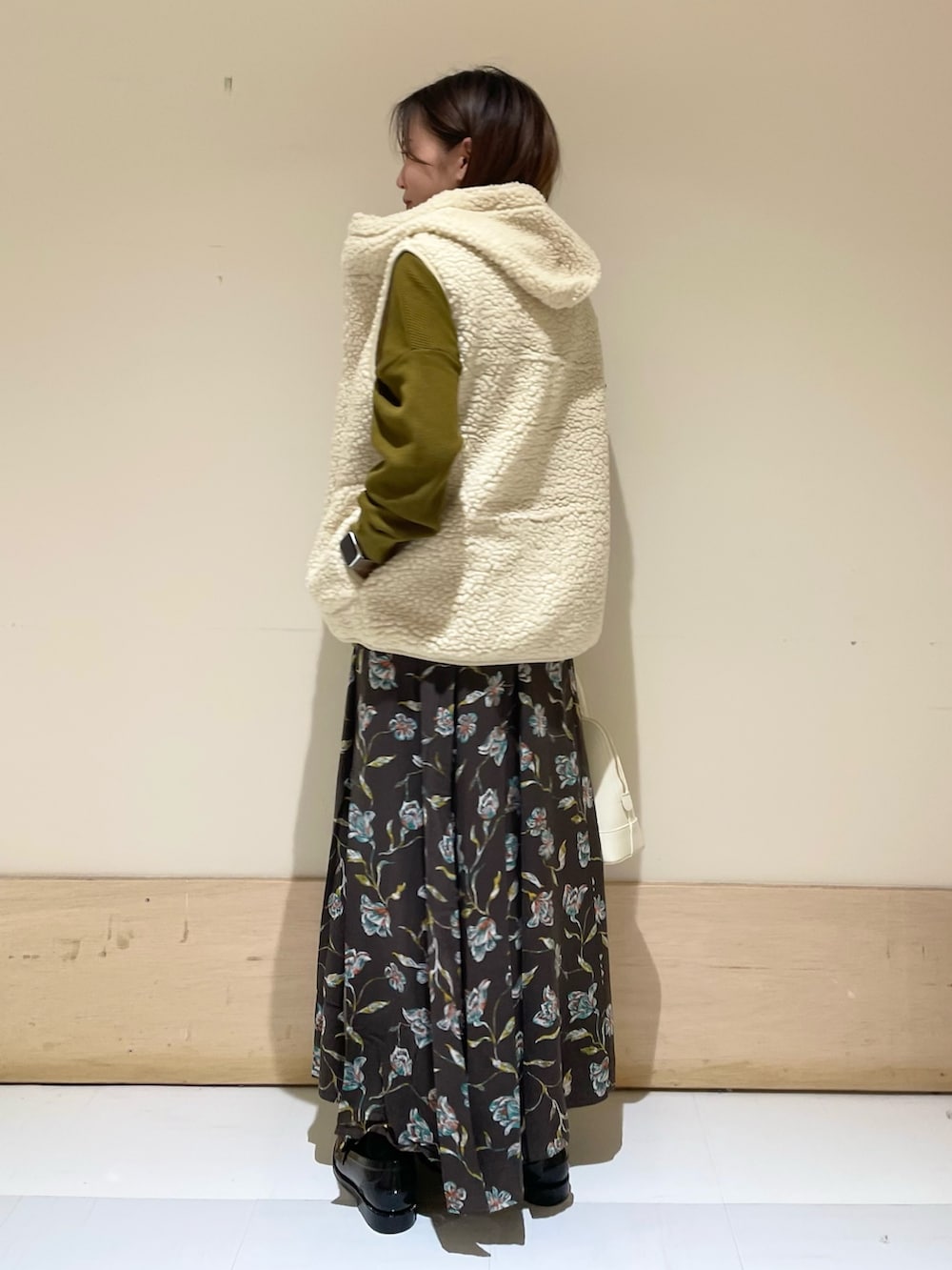 ホワイト系のショルダーバッグ、ブラック系のレインシューズ、イエロー系のTシャツ/カットソーを着用したレディースの秋コーディネートの5枚目の写真