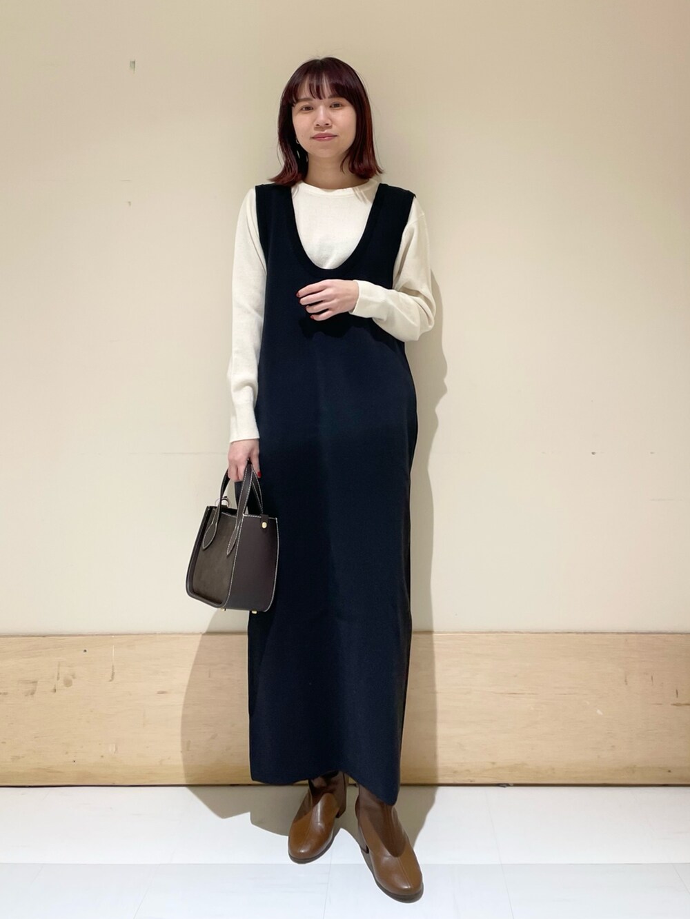 ブラック系のワンピース、ホワイト系のニット/セーターを着用したレディースの冬コーディネートの2枚目の写真