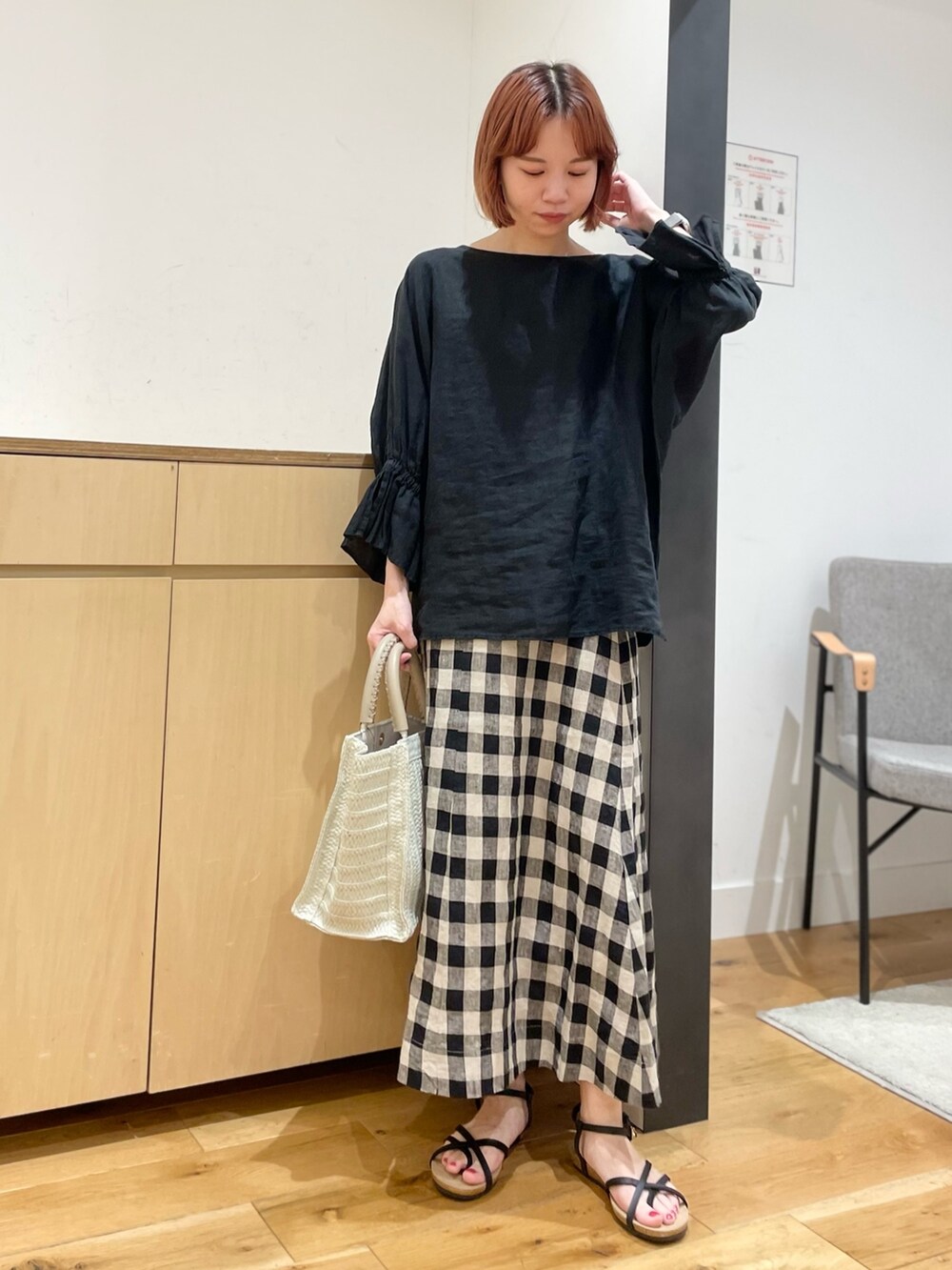 ブラック系のスカート、ベージュ系のトートバッグ、ブラック系のシャツ/ブラウスを着用したレディースの春コーディネートの2枚目の写真