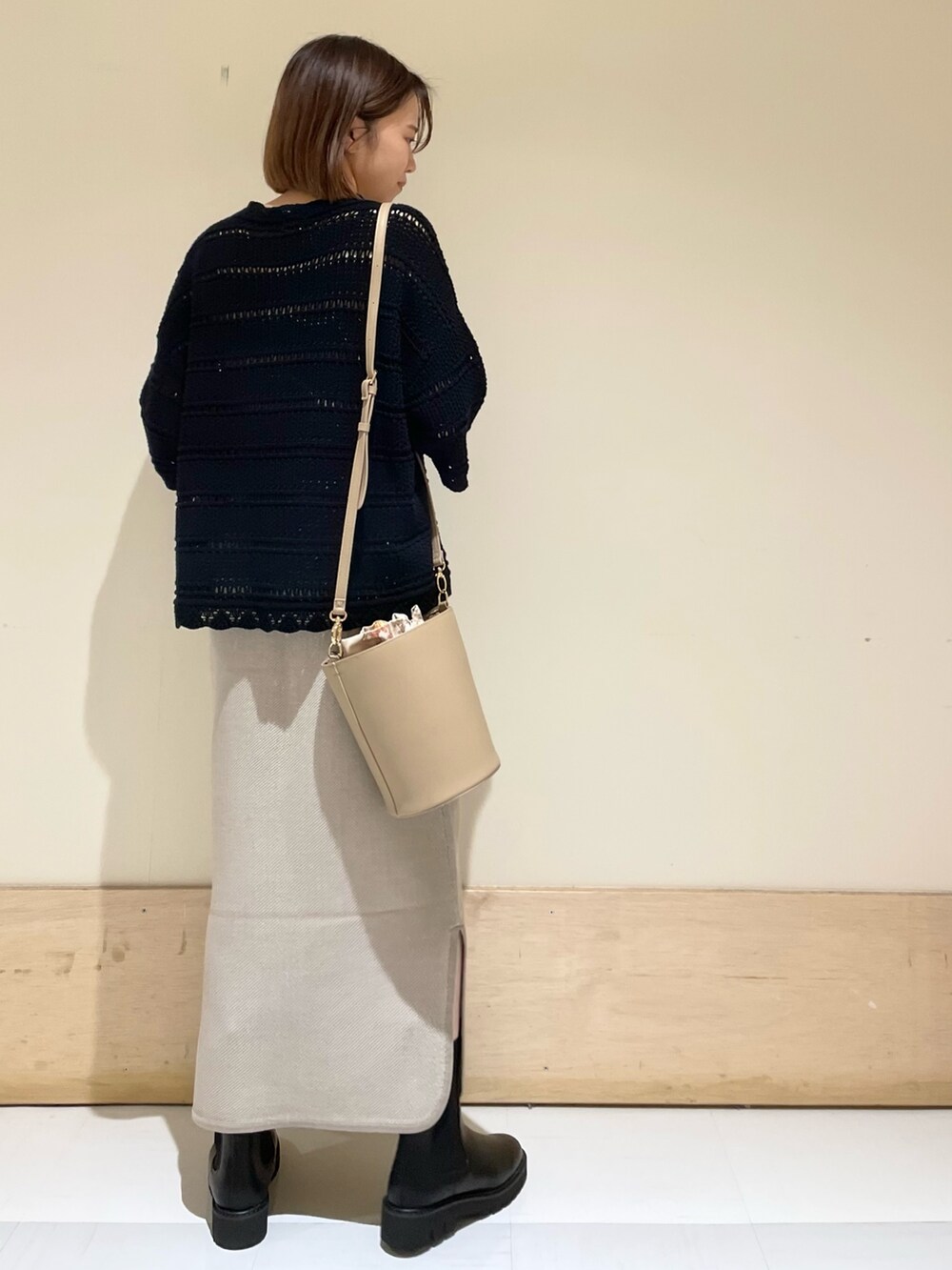 ベージュ系のショルダーバッグ、ブラック系のブーツ、ブラック系のニット/セーターを着用したレディースの秋コーディネートの7枚目の写真