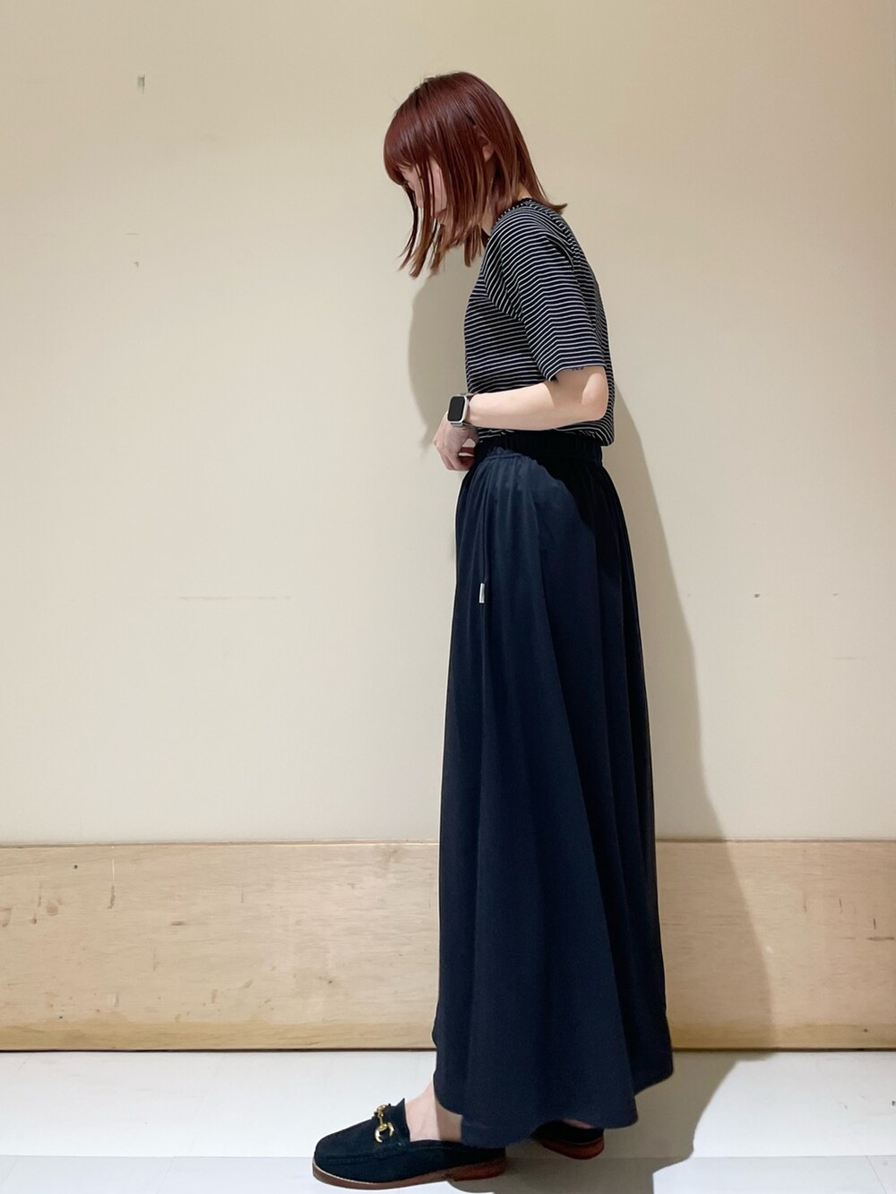 ブルー系のその他シューズ、ブルー系のスカート、ブラック系のハンドバッグを着用したレディースの春コーディネートの4枚目の写真