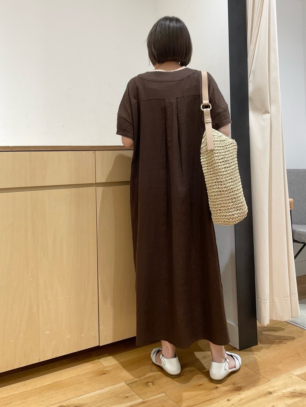 ホワイト系のサンダル、ベージュ系のかごバッグ、ブラウン系のワンピースを着用したレディースの夏コーディネートの6枚目の写真