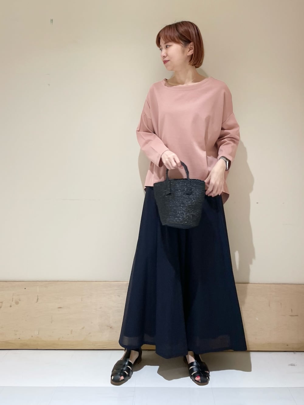 ピンク系のTシャツ/カットソー、ブルー系のスカート、ブラック系のハンドバッグを着用したレディースの春コーディネートの3枚目の写真