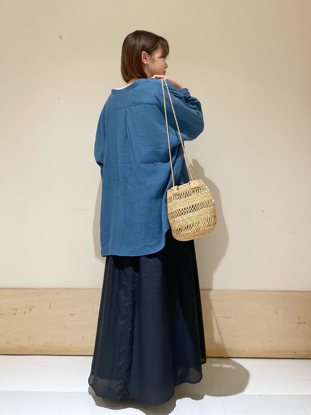 ブラック系のスカート、ベージュ系のショルダーバッグ、グレー系のTシャツ/カットソーを着用したレディースの夏コーディネートの7枚目の写真