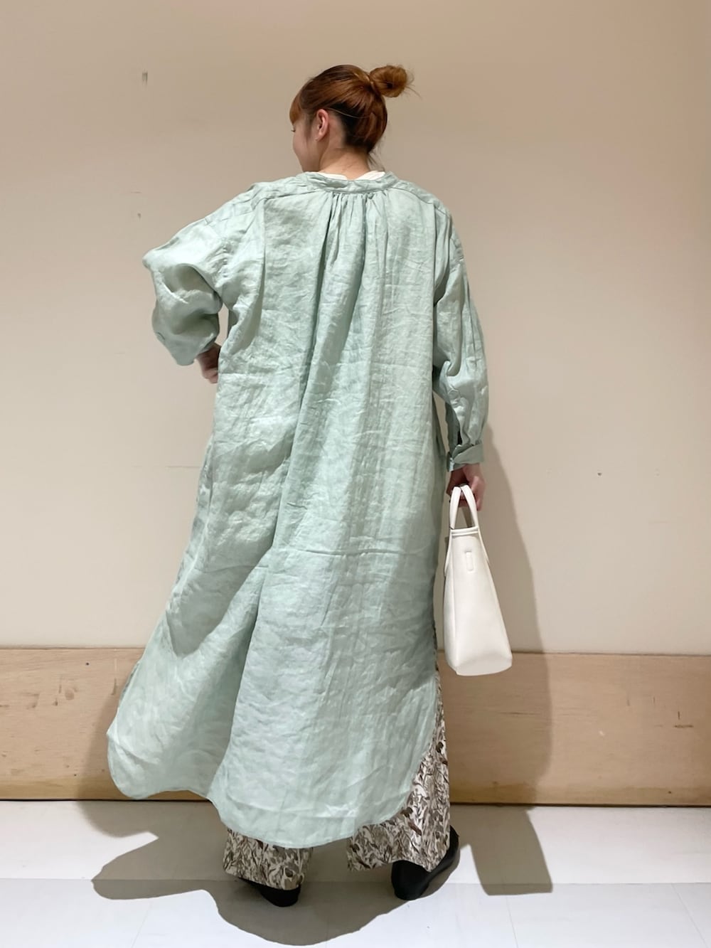 グリーン系のワンピース、ホワイト系のTシャツ/カットソー、ホワイト系のトートバッグを着用したレディースの春コーディネートの4枚目の写真