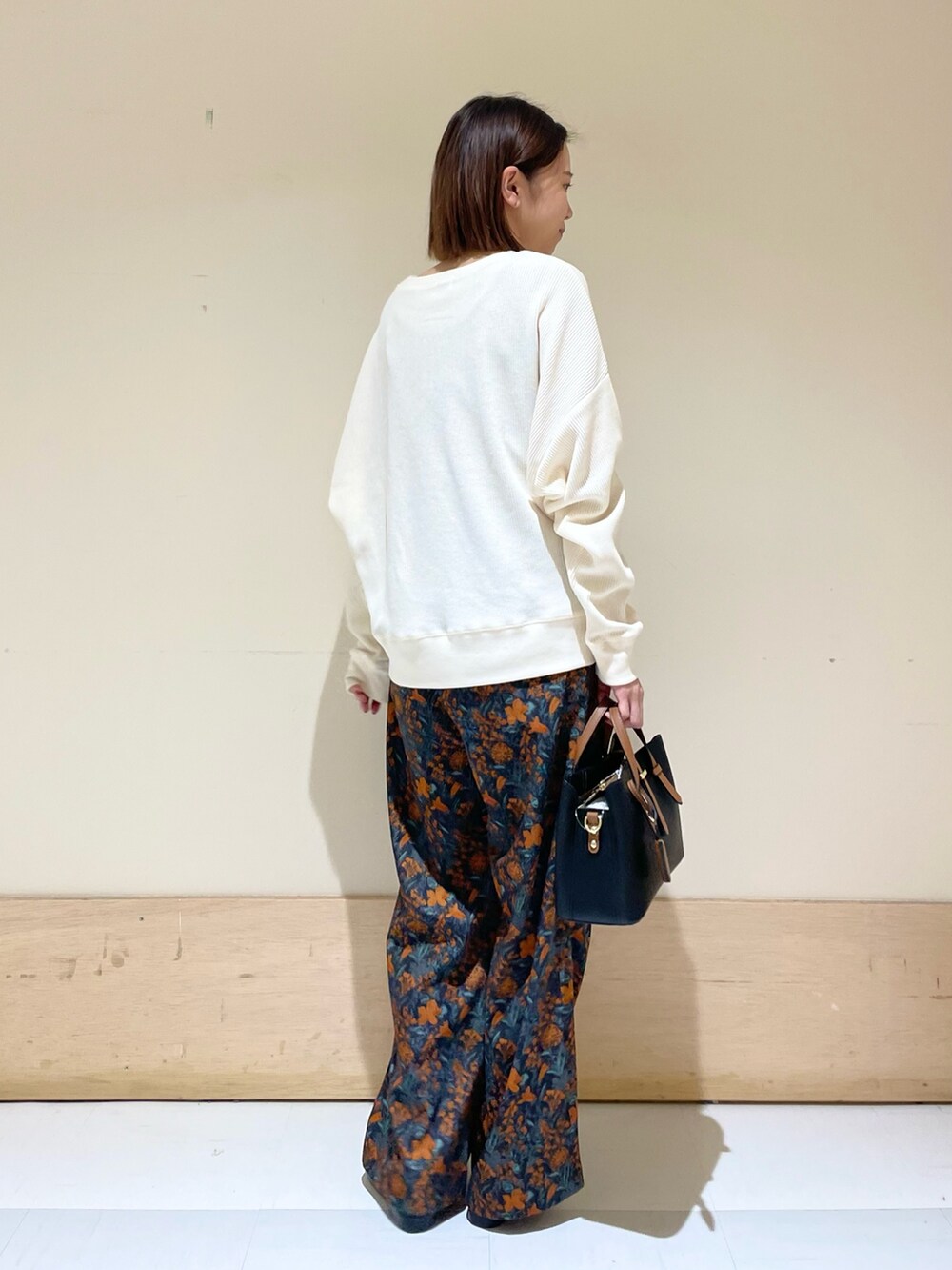 オレンジ系のその他パンツ、ブラック系のハンドバッグ、ブラック系のローファーを着用したレディースの秋コーディネートの8枚目の写真