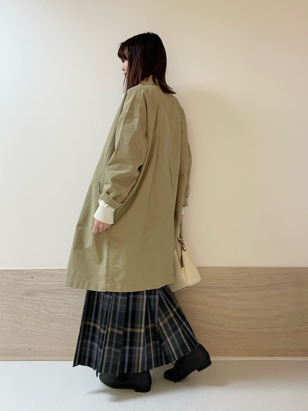 グレー系のスカート、ホワイト系のニット/セーター、ベージュ系のその他アウターを着用したレディースの春コーディネートの7枚目の写真