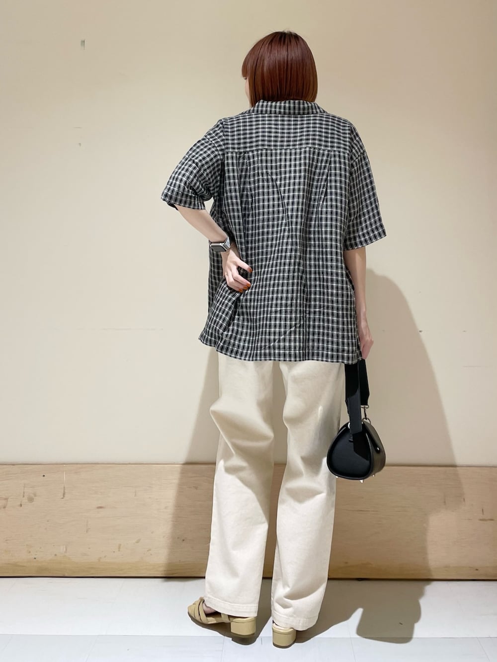 ホワイト系のTシャツ/カットソー、ベージュ系のデニムパンツ、ブラック系のショルダーバッグを着用したレディースの春コーディネートの4枚目の写真